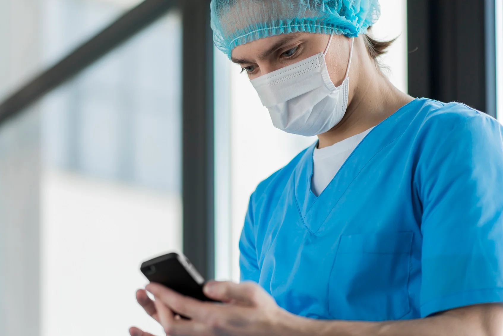 Clinician using a phone in a hospital corridor